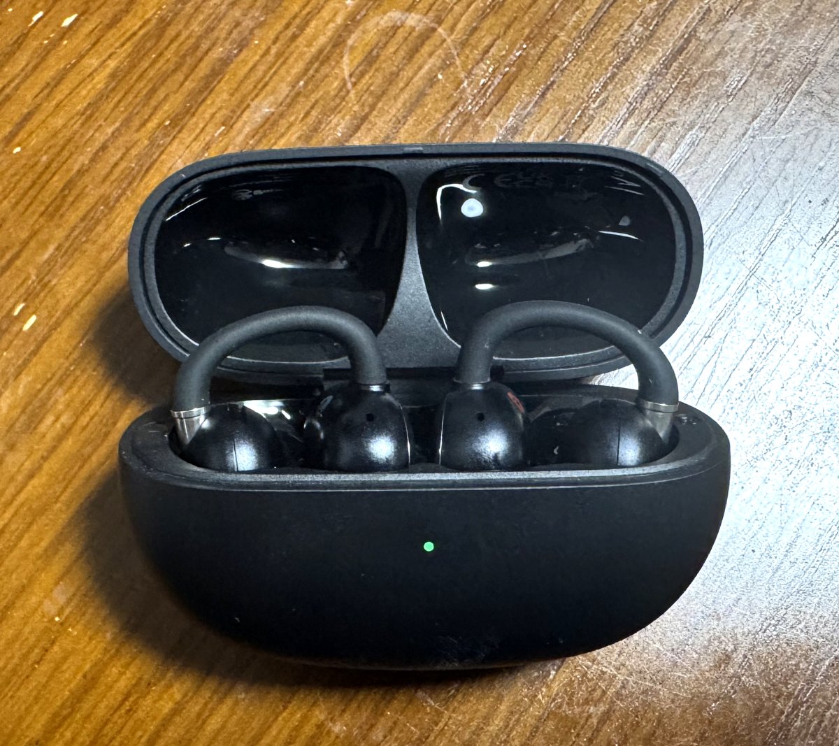 EarFun Clip 2のケースを開けた状態。左右のイヤホンが収まり、インジケーターが緑に点灯している