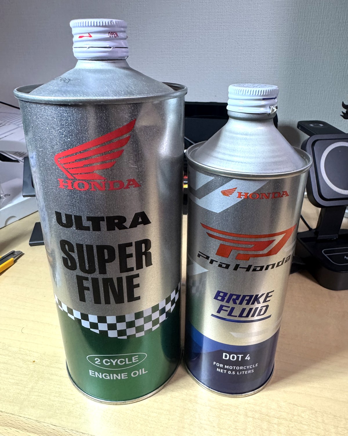 ホンダ純正のウルトラ スーパーファイン2サイクルオイル1L缶とProHonda DOT4ブレーキフルード0.5L缶を並べたところ