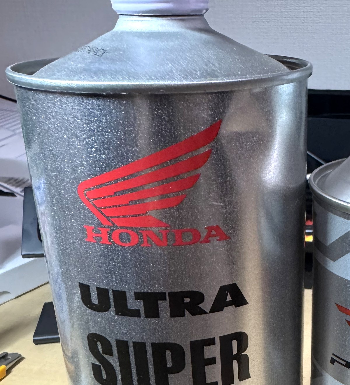 ホンダ ウルトラ SUPER FINE 2サイクルエンジンオイルの1L缶。緑色のラベルにチェッカー模様が入っている