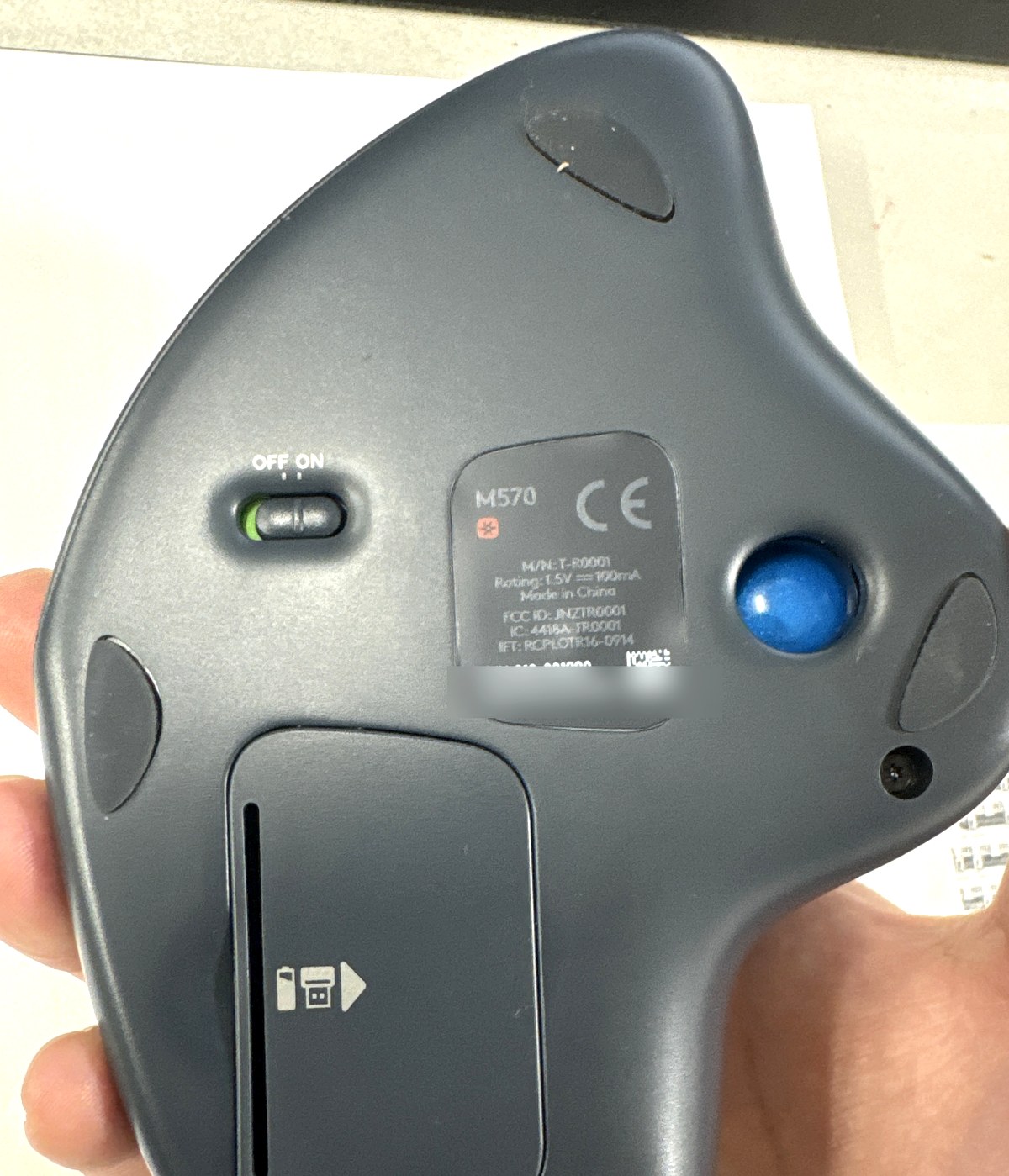 M570の裏面。M570の表示、電源スイッチ、電池蓋とレシーバー収納の図示が見える