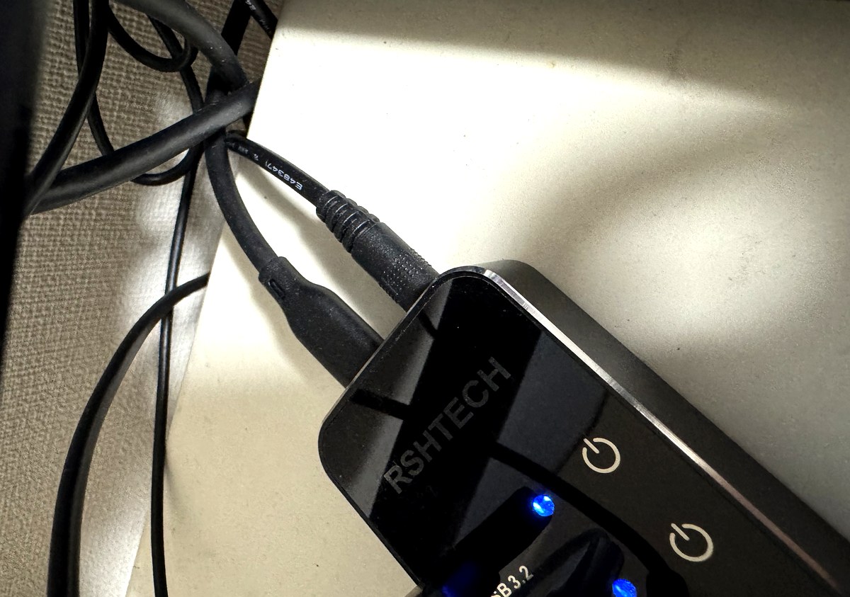 RSHTECHのUSBハブ本体。黒い天面に電源マークのスイッチと青いLEDが並んでいる